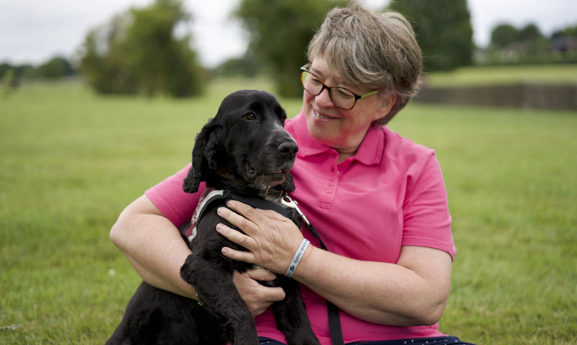 A lady called Sue with her hearing dog Kristo, a black cocker spaniel