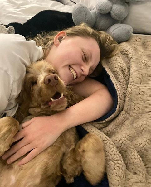 Ameila and hearing dog scamp cuddling