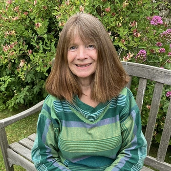 Midshot of a smiling woman sat in a garden