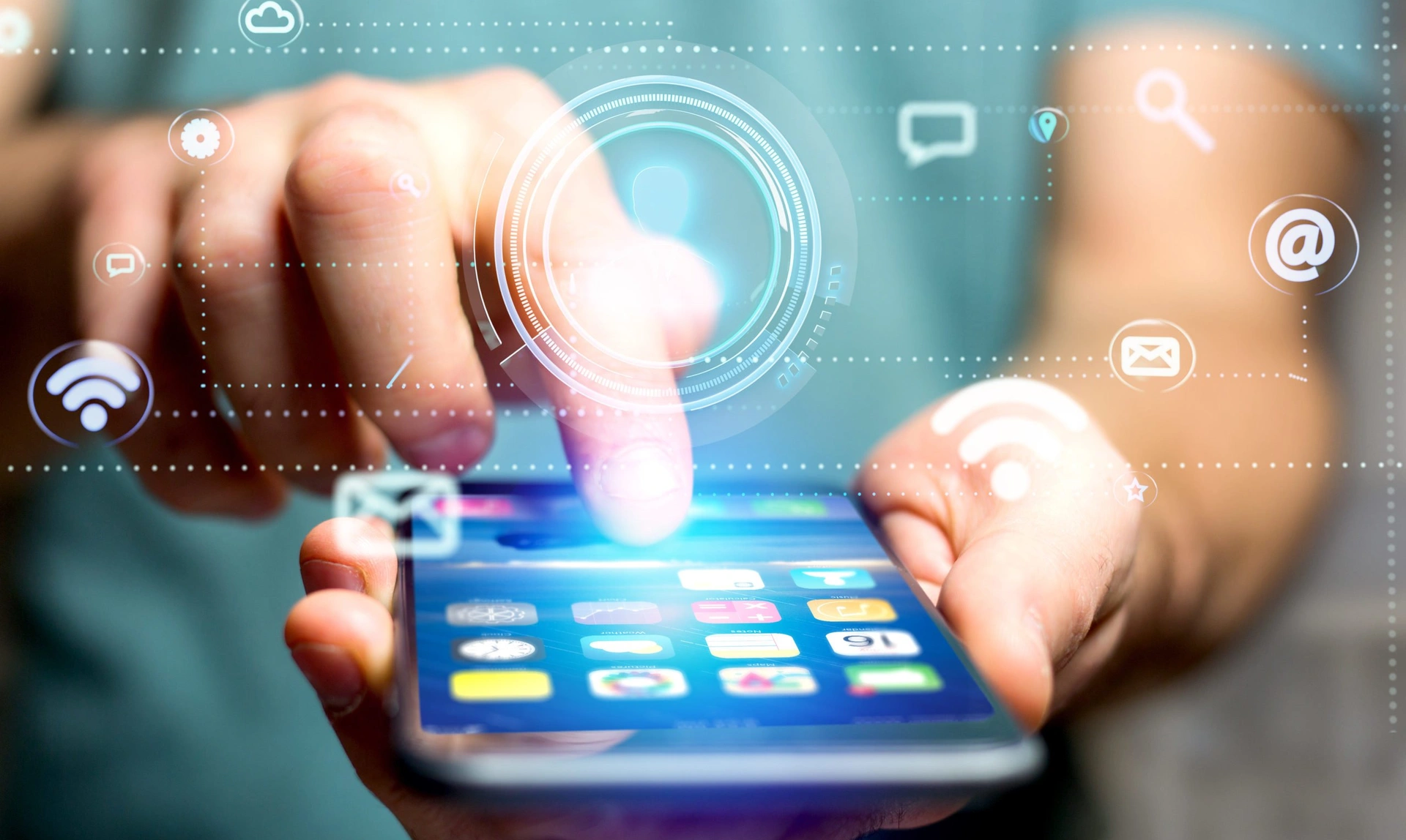 Close up on a hand holding a mobile phone with icons floating in the air around it