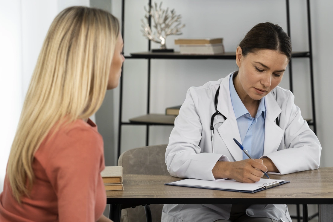 Side view of a young woman talking to a doctor