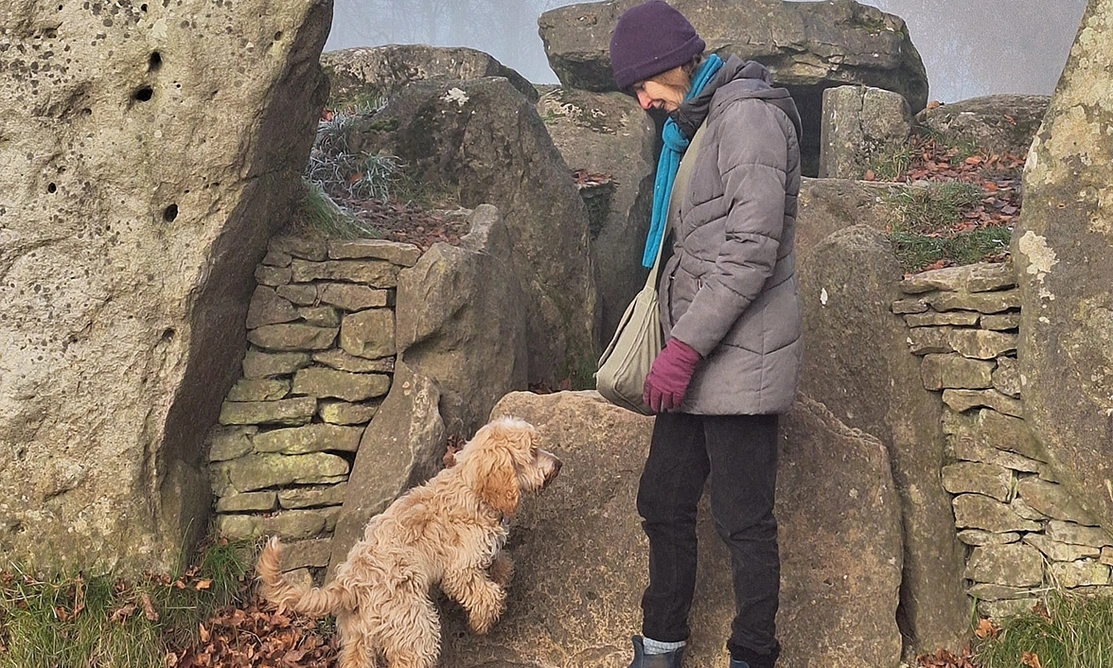 Golden Cockapoo and lady standing by historical ruins